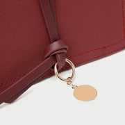 Knotted strap metal disc embellished PU leather crossbody bag